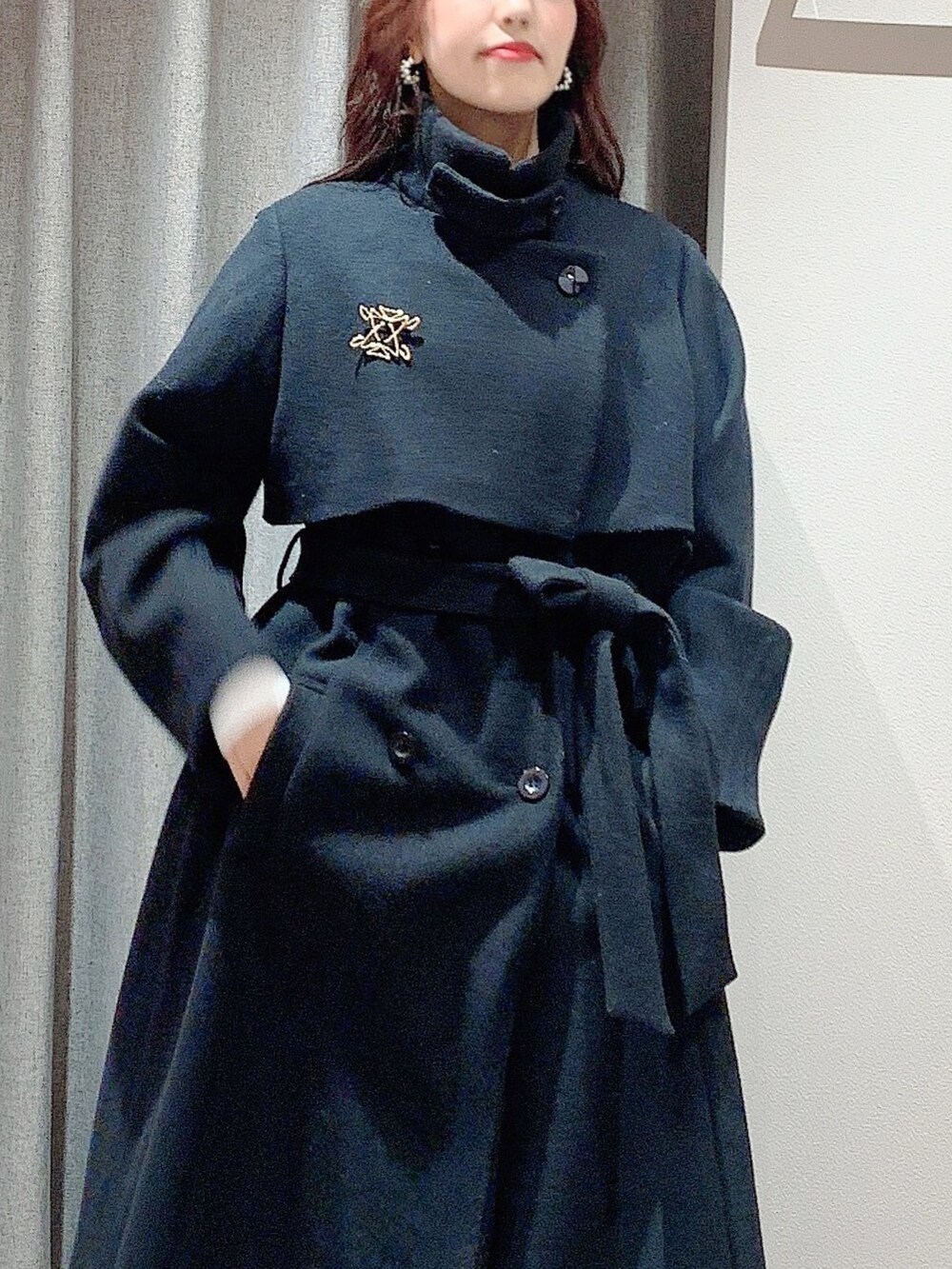 ホワイト系のワンピース、ホワイト系のブーツ、ブラック系のその他アウターを着用したレディースの冬コーディネートの8枚目の写真