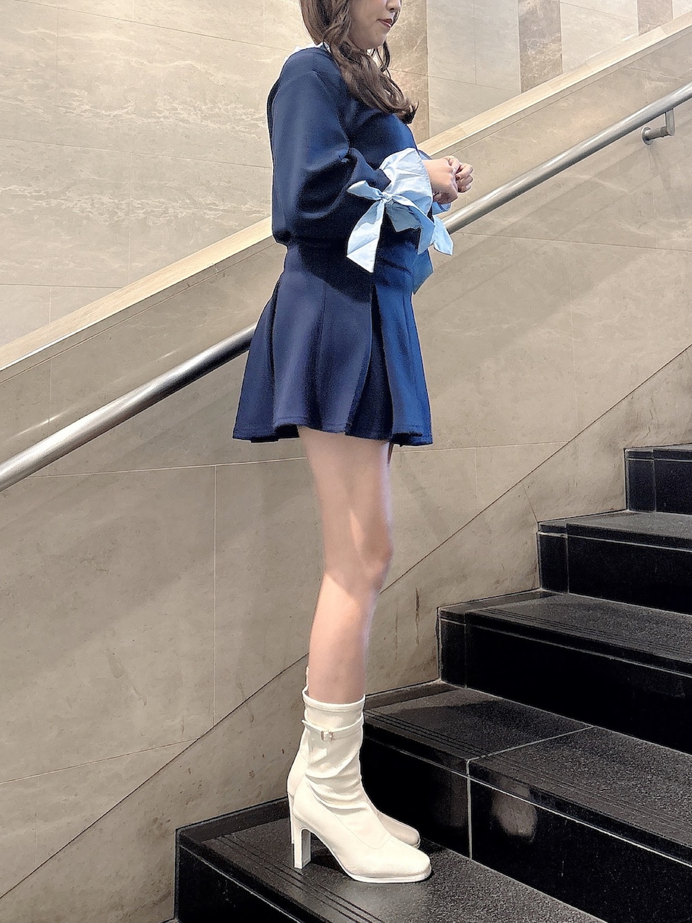 ブルー系のTシャツ/カットソー、ブルー系のスカート、ホワイト系のブーツを着用したレディースの春コーディネートの3枚目の写真