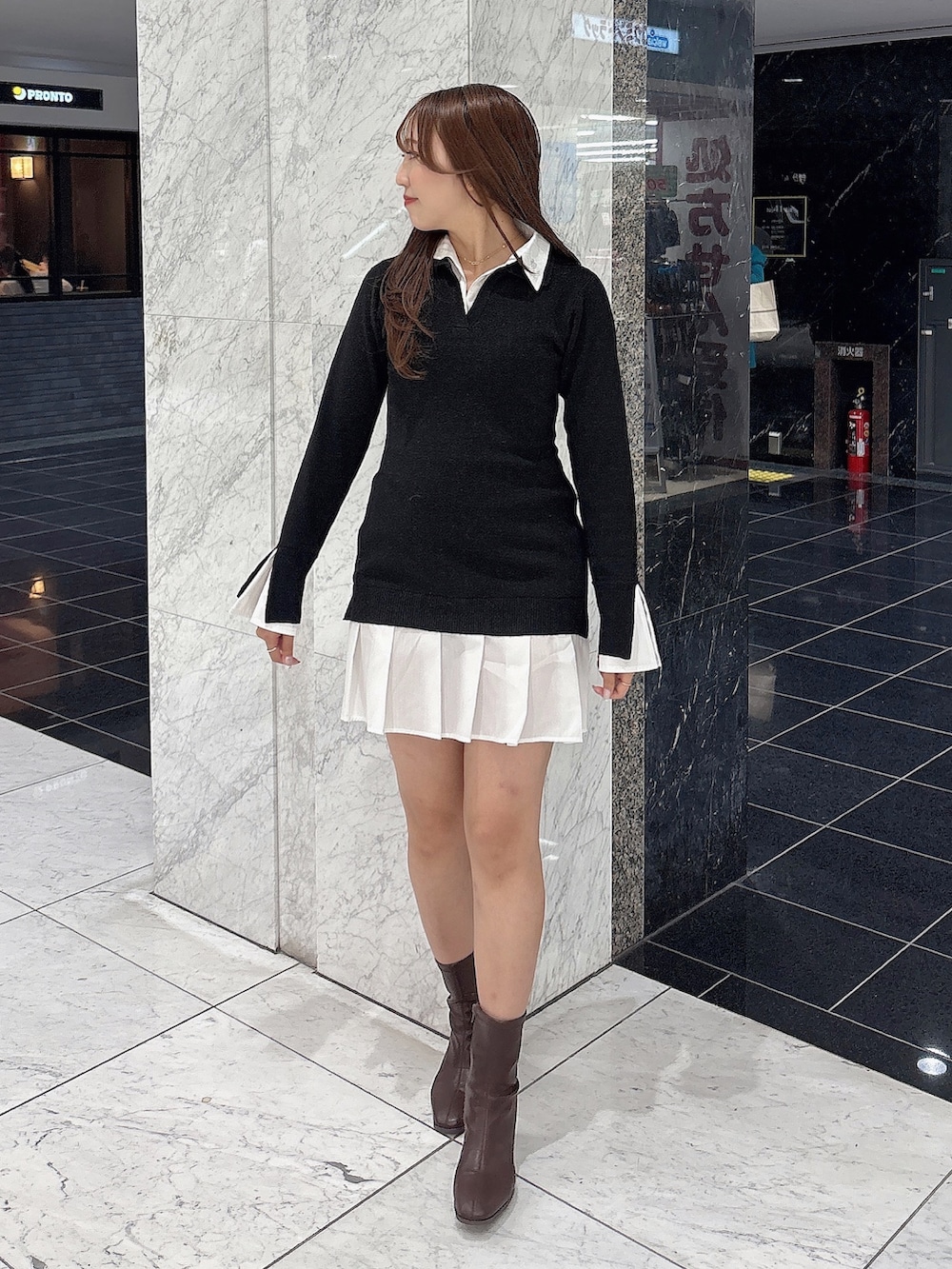 ブラック系のワンピース、ブラウン系のブーツを着用したレディースの秋コーディネートの3枚目の写真