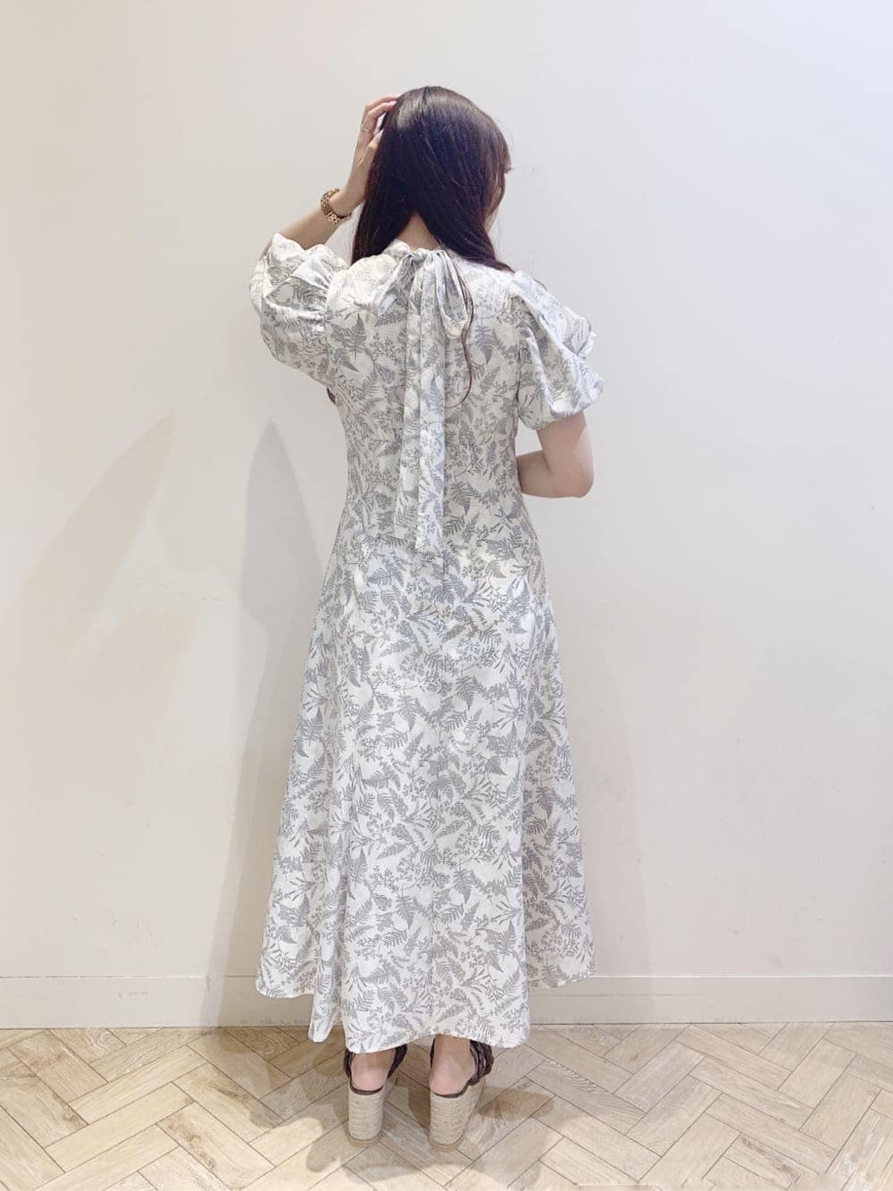 ホワイト系のワンピース、ブラウン系のサンダルを着用したレディースの春コーディネートの4枚目の写真