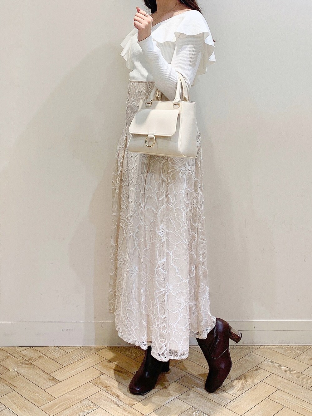 ベージュ系のスカート、ブラウン系のブーツ、ホワイト系のニット/セーターを着用したレディースの冬コーディネートの4枚目の写真