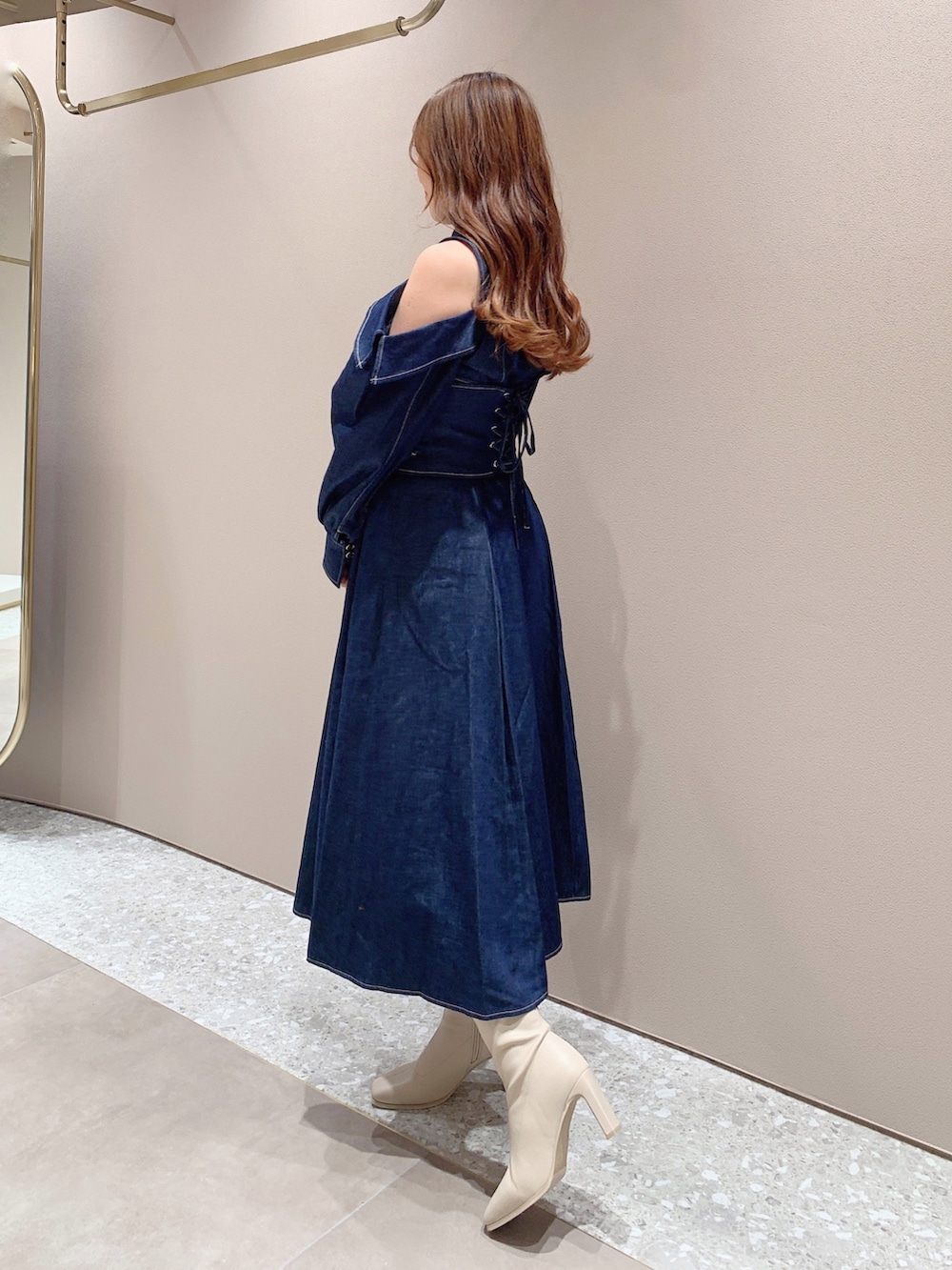 ホワイト系のブーツ、ブルー系のワンピースを着用したレディースの秋コーディネートの4枚目の写真