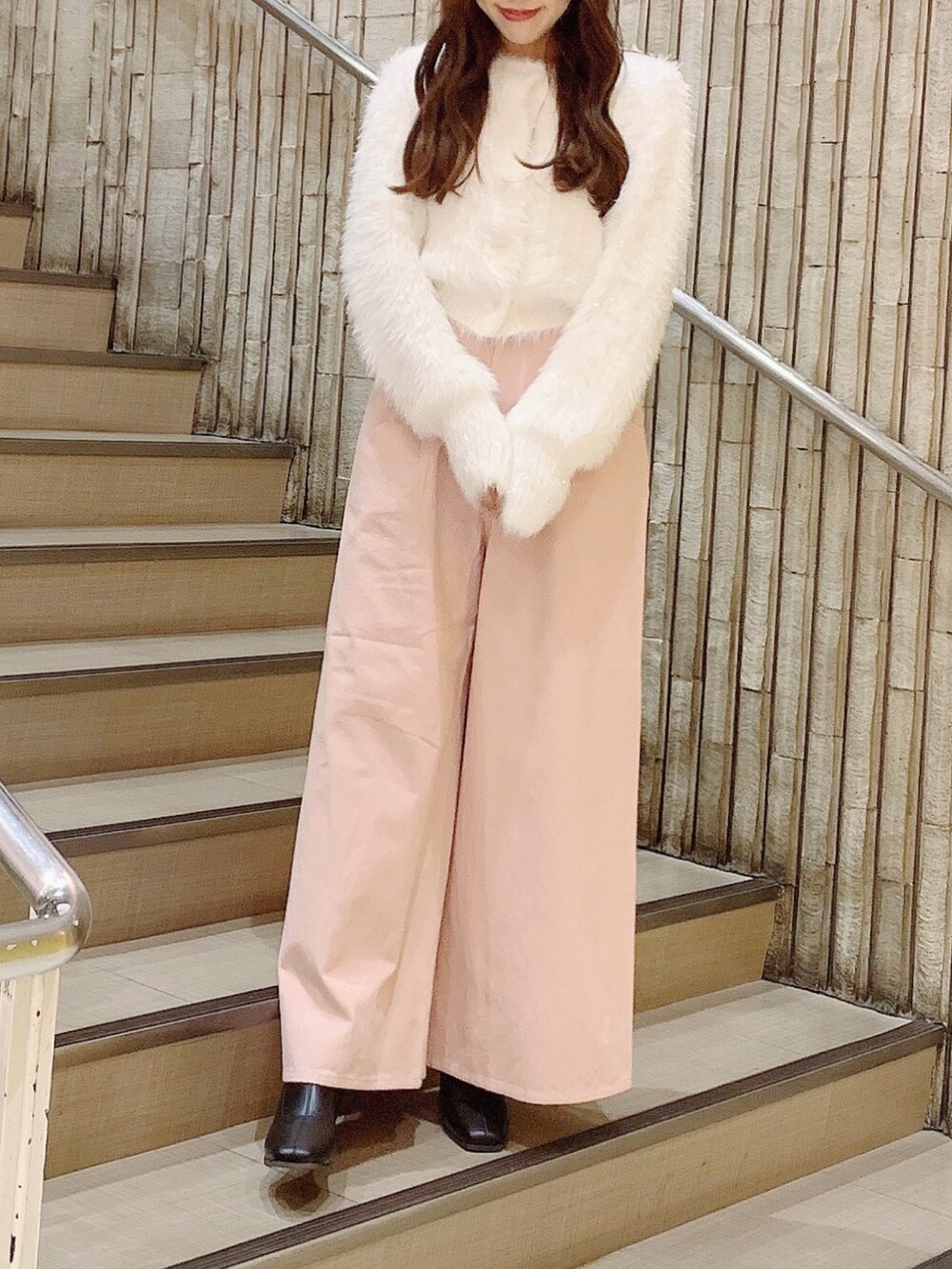 ブラック系のブーツ、ピンク系のデニムパンツ、ホワイト系のカーディガン/ボレロを着用したレディースの秋コーディネートの2枚目の写真