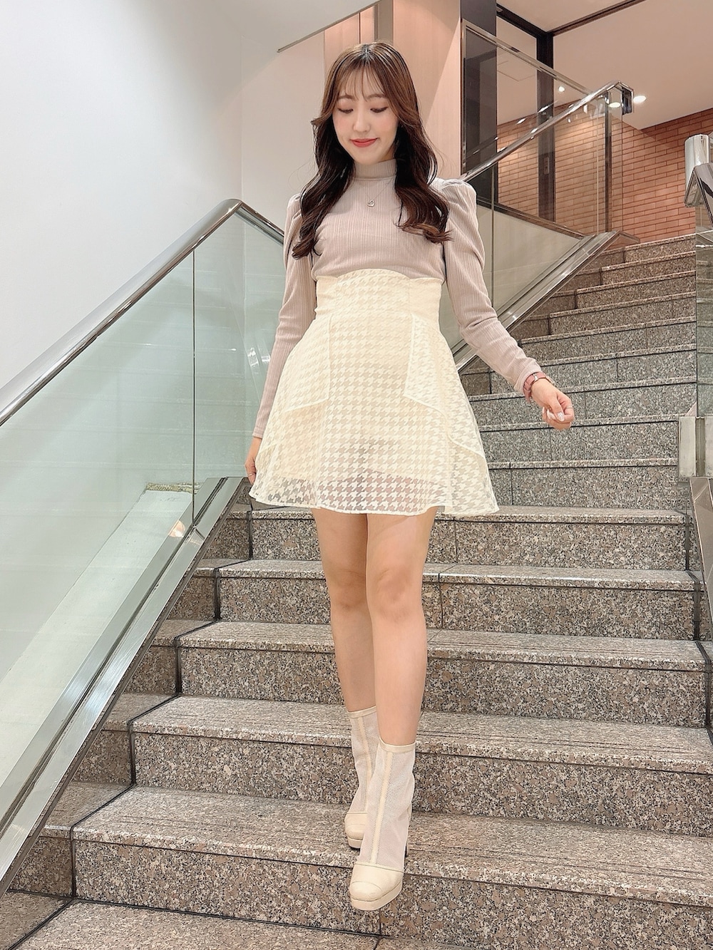 ホワイト系のブーツ、ベージュ系のワンピースを着用したレディースの冬コーディネートの2枚目の写真