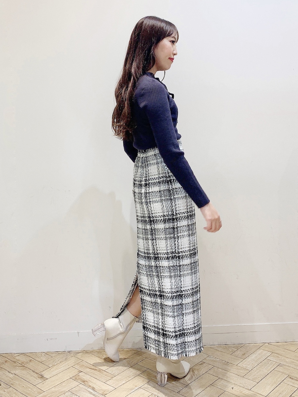 ホワイト系のスカート、ブラウン系のニット/セーター、ホワイト系のブーツを着用したレディースの秋コーディネートの4枚目の写真