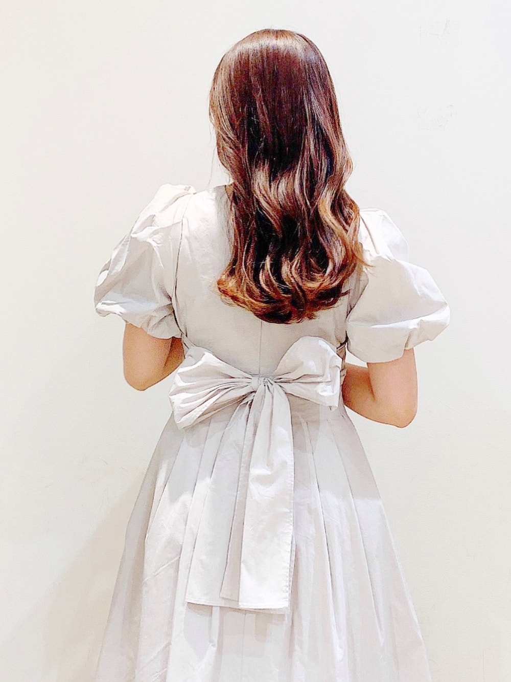 ホワイト系のワンピース、グレー系のスニーカーを着用したレディースの春コーディネートの7枚目の写真