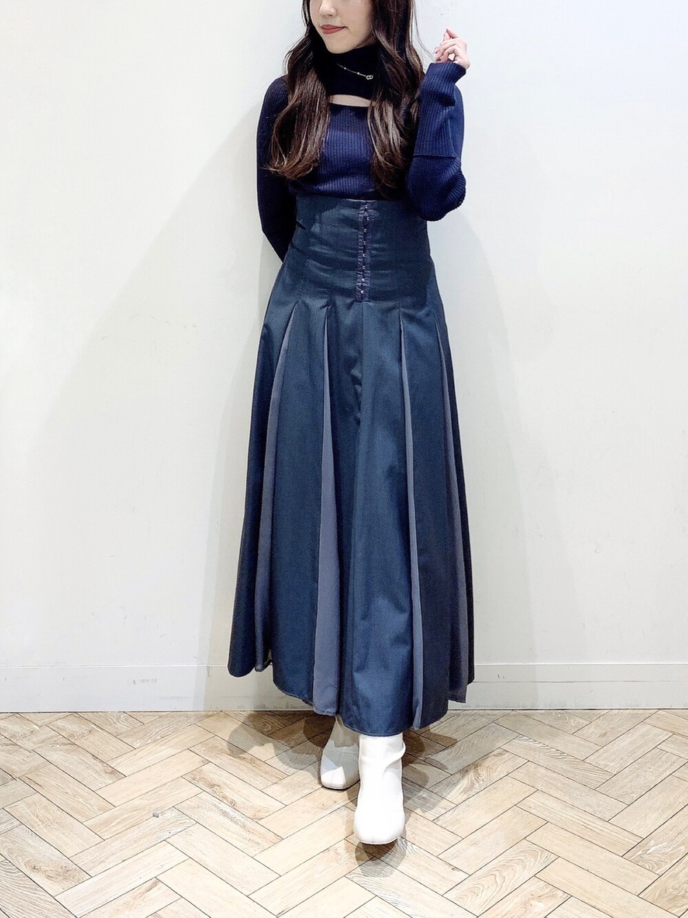 グレー系のニット/セーター、グレー系のスカート、ホワイト系のブーツを着用したレディースの冬コーディネートの4枚目の写真