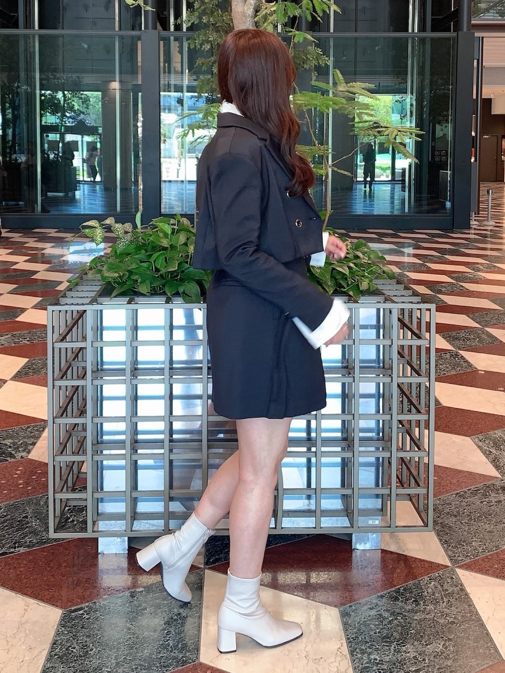 ブラック系のスカート、ブラック系のテーラードジャケット、ベージュ系のブーツを着用したレディースの秋コーディネートの7枚目の写真