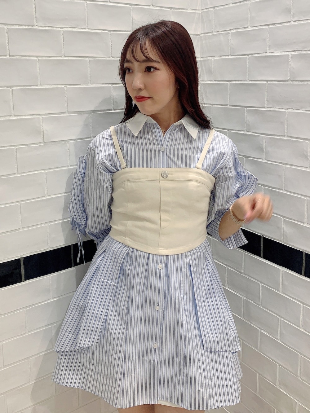 ブルー系のシャツワンピース、ホワイト系のブーツ、ホワイト系のキャミソールを着用したレディースの春コーディネートの6枚目の写真