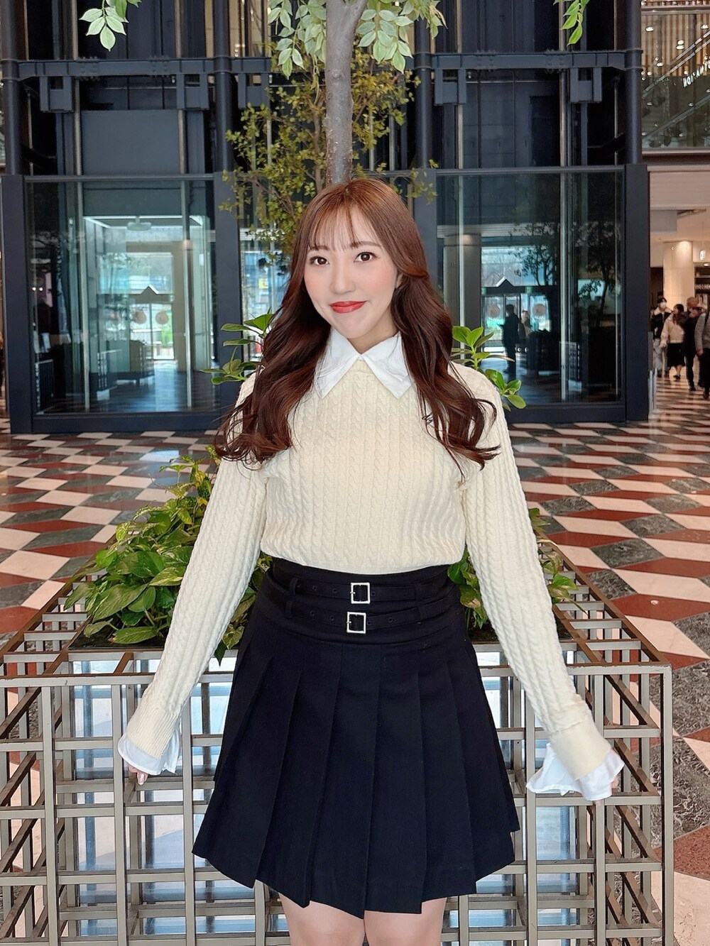 ホワイト系のブーツ、ブラック系のスカート、ホワイト系のニット/セーターを着用したレディースの冬コーディネートの9枚目の写真