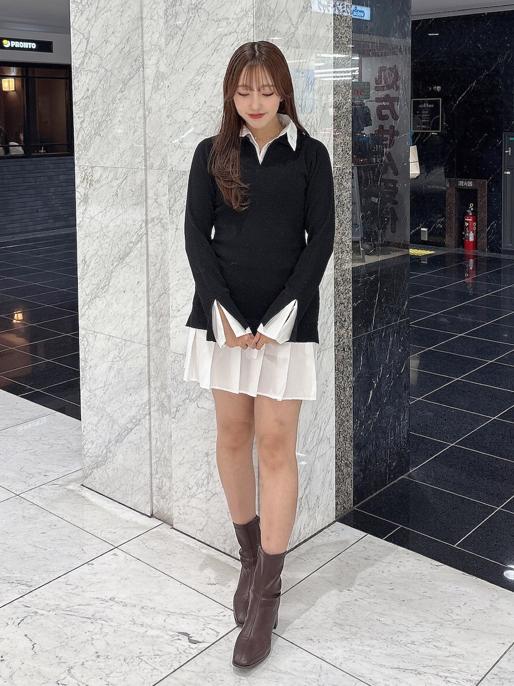 ブラック系のワンピース、ブラウン系のブーツを着用したレディースの秋コーディネートの2枚目の写真