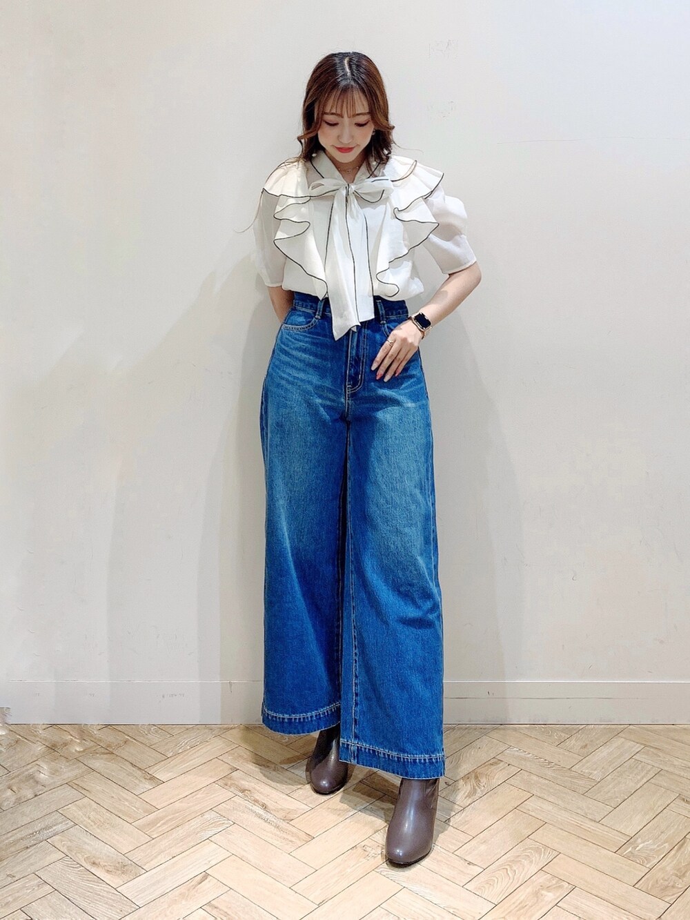 ホワイト系のシャツ/ブラウス、ブラウン系のブーツ、ブルー系のデニムパンツを着用したレディースの夏コーディネートの2枚目の写真