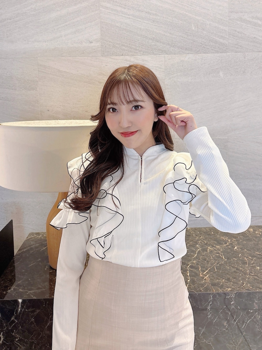 ベージュ系のスカート、ホワイト系のTシャツ/カットソー、ブラック系のパンプスを着用したレディースの春コーディネートの6枚目の写真