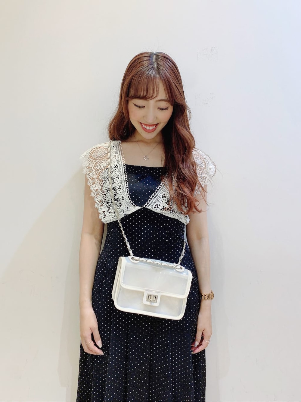 ホワイト系のパンプス、ブラック系のワンピース、ホワイト系のショルダーバッグを着用したレディースの春コーディネートの6枚目の写真