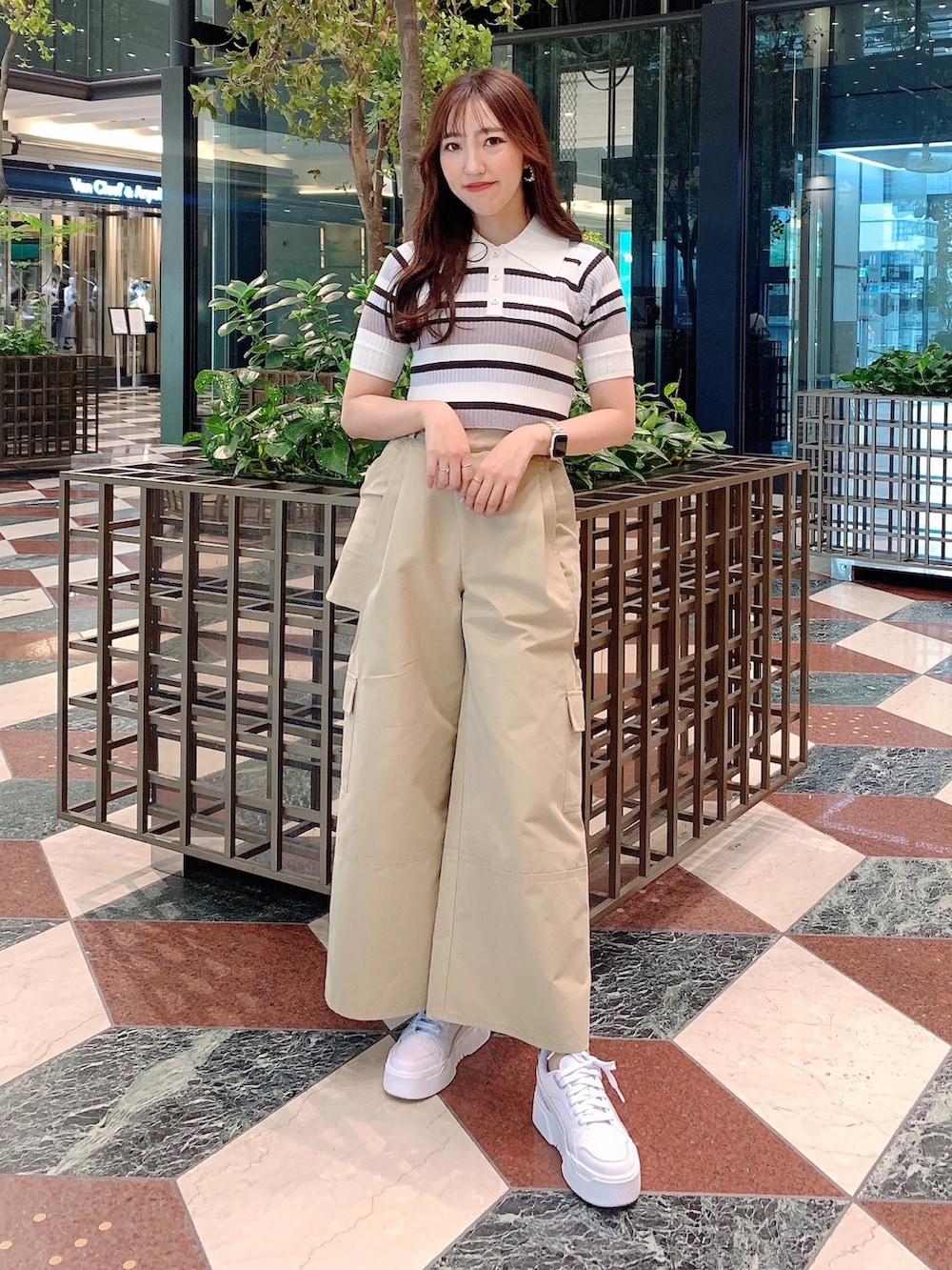 ベージュ系のチノパンツ、グレー系のニット/セーターを着用したレディースの春コーディネートの2枚目の写真