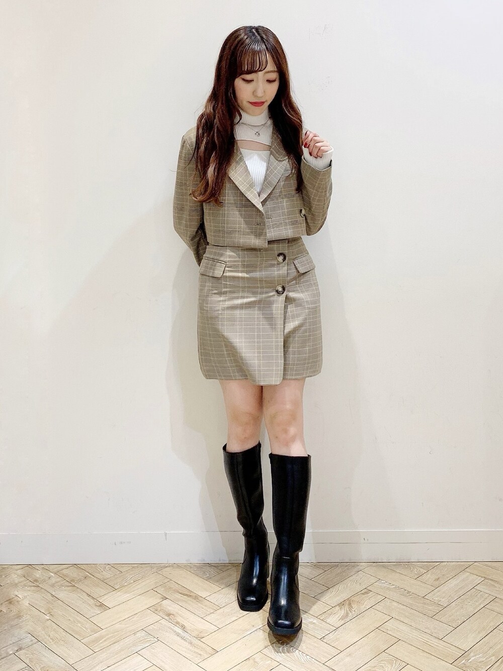 ホワイト系のニット/セーター、ブラック系のブーツ、ベージュ系のテーラードジャケットを着用したレディースの秋コーディネートの2枚目の写真