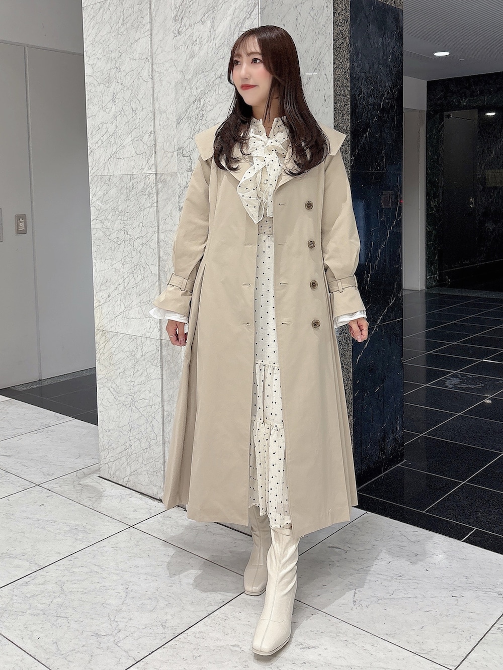 ホワイト系のブーツ、ベージュ系のトレンチコート、ホワイト系のワンピースを着用したレディースの冬コーディネートの6枚目の写真