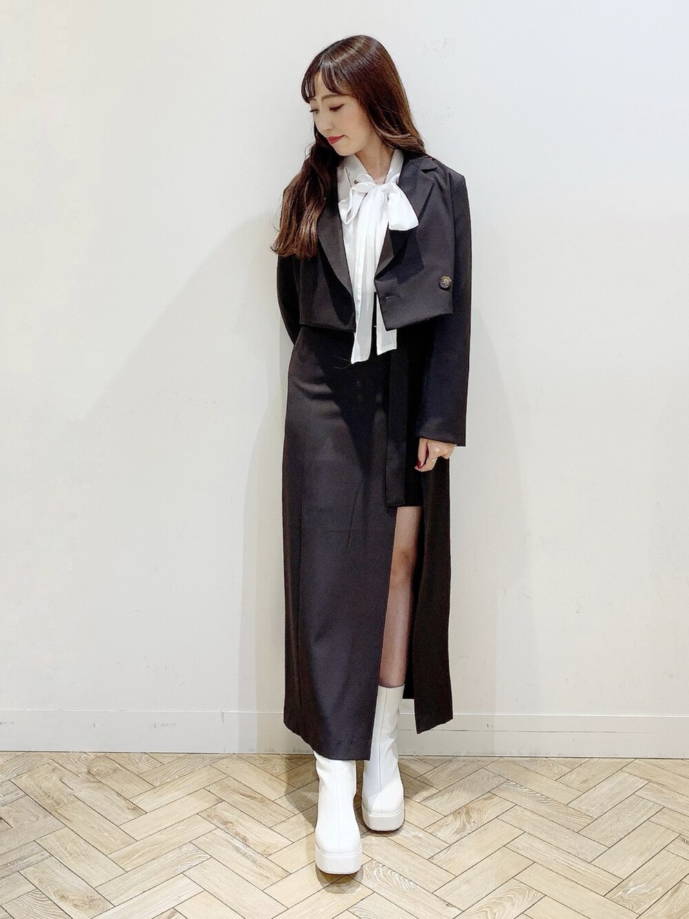 ブラウン系のスカート、ホワイト系のブーツ、ホワイト系のシャツ/ブラウスを着用したレディースの秋コーディネートの2枚目の写真