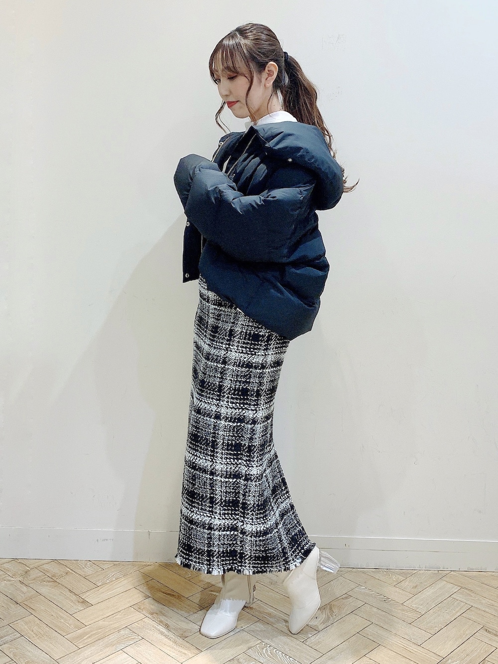 ブラック系のダウンジャケット/コート、ホワイト系のシャツ/ブラウス、ブラック系のスカートを着用したレディースの冬コーディネートの9枚目の写真