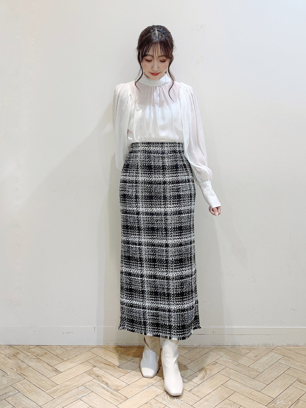 ブラック系のダウンジャケット/コート、ホワイト系のシャツ/ブラウス、ブラック系のスカートを着用したレディースの冬コーディネートの4枚目の写真