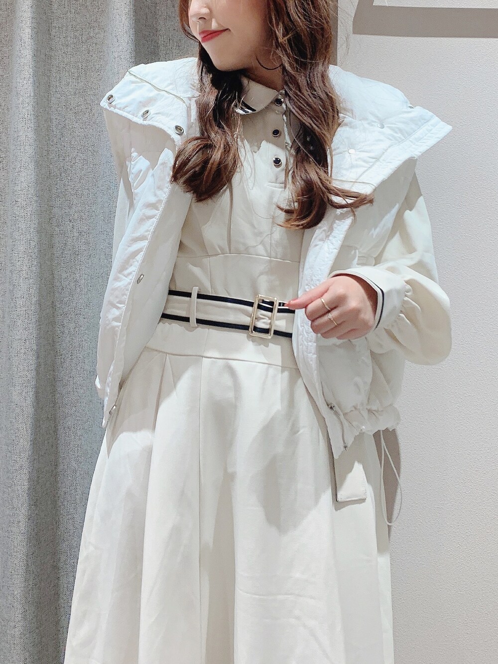 ベージュ系のパンプス、ホワイト系のワンピース、ホワイト系のダウンジャケット/コートを着用したレディースの秋コーディネートの9枚目の写真