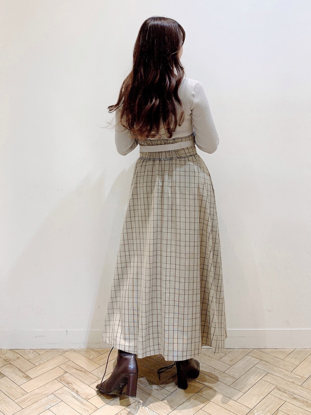 ブラウン系のチェスターコート、ブラウン系のブーツ、ベージュ系のワンピースを着用したレディースの冬コーディネートの6枚目の写真