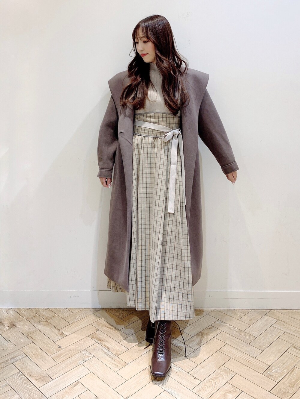 ブラウン系のチェスターコート、ブラウン系のブーツ、ベージュ系のワンピースを着用したレディースの冬コーディネートの8枚目の写真