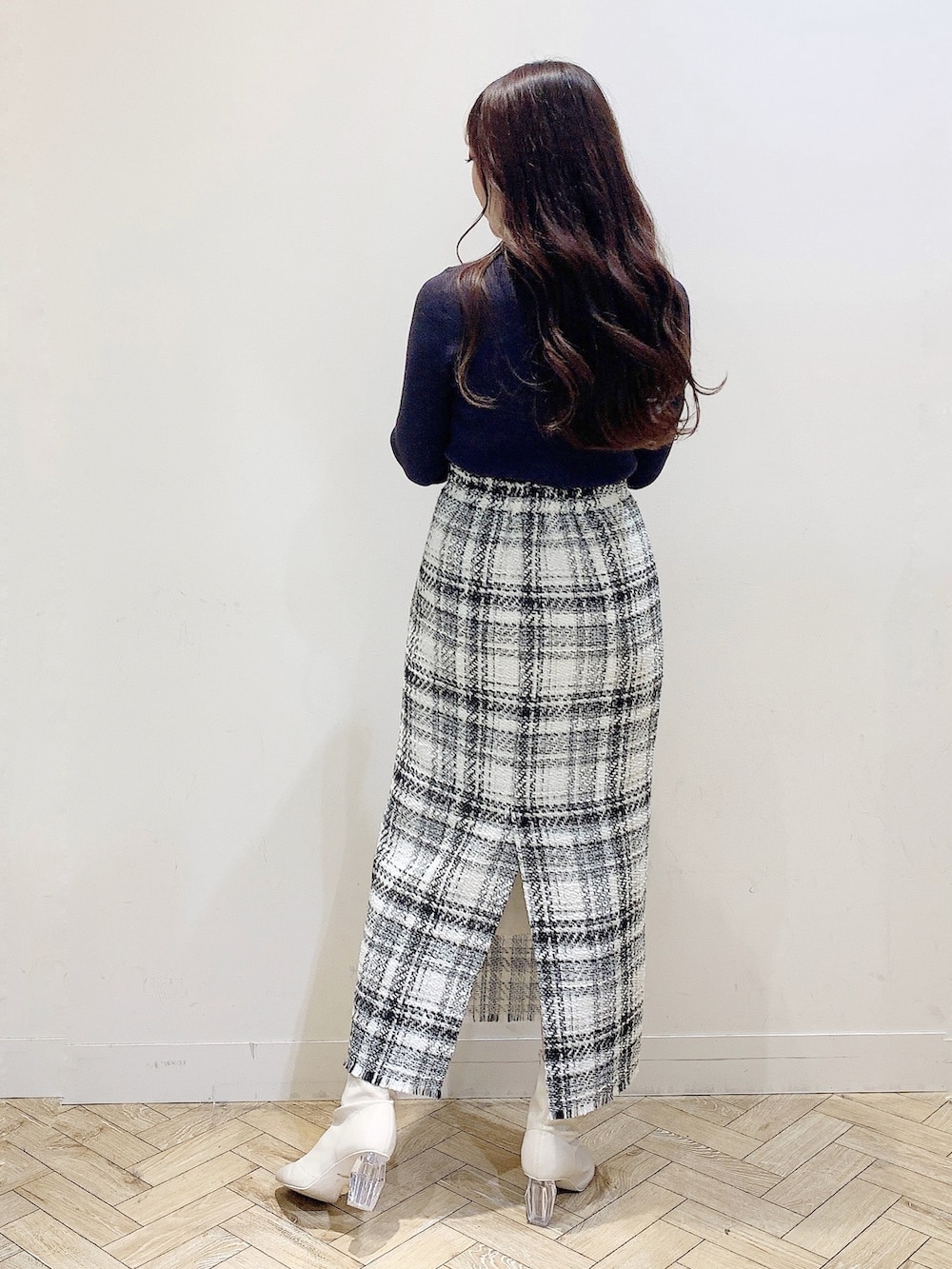 ホワイト系のスカート、ブラウン系のニット/セーター、ホワイト系のブーツを着用したレディースの秋コーディネートの5枚目の写真