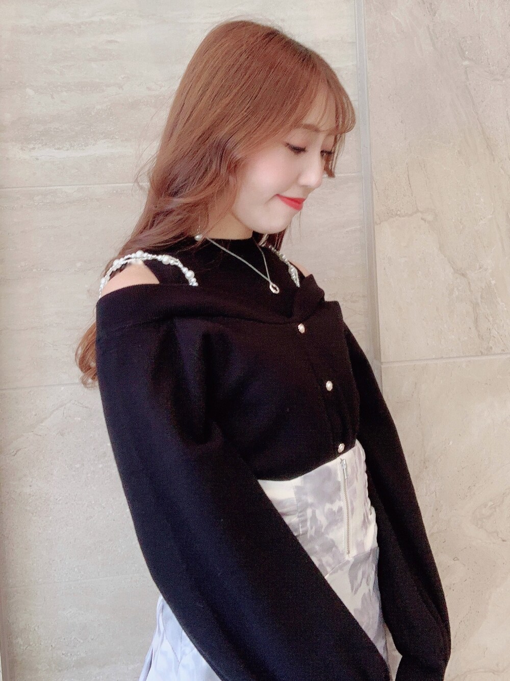 ホワイト系のスカート、ブラック系のニット/セーター、ブラック系のパンプスを着用したレディースの秋コーディネートの8枚目の写真