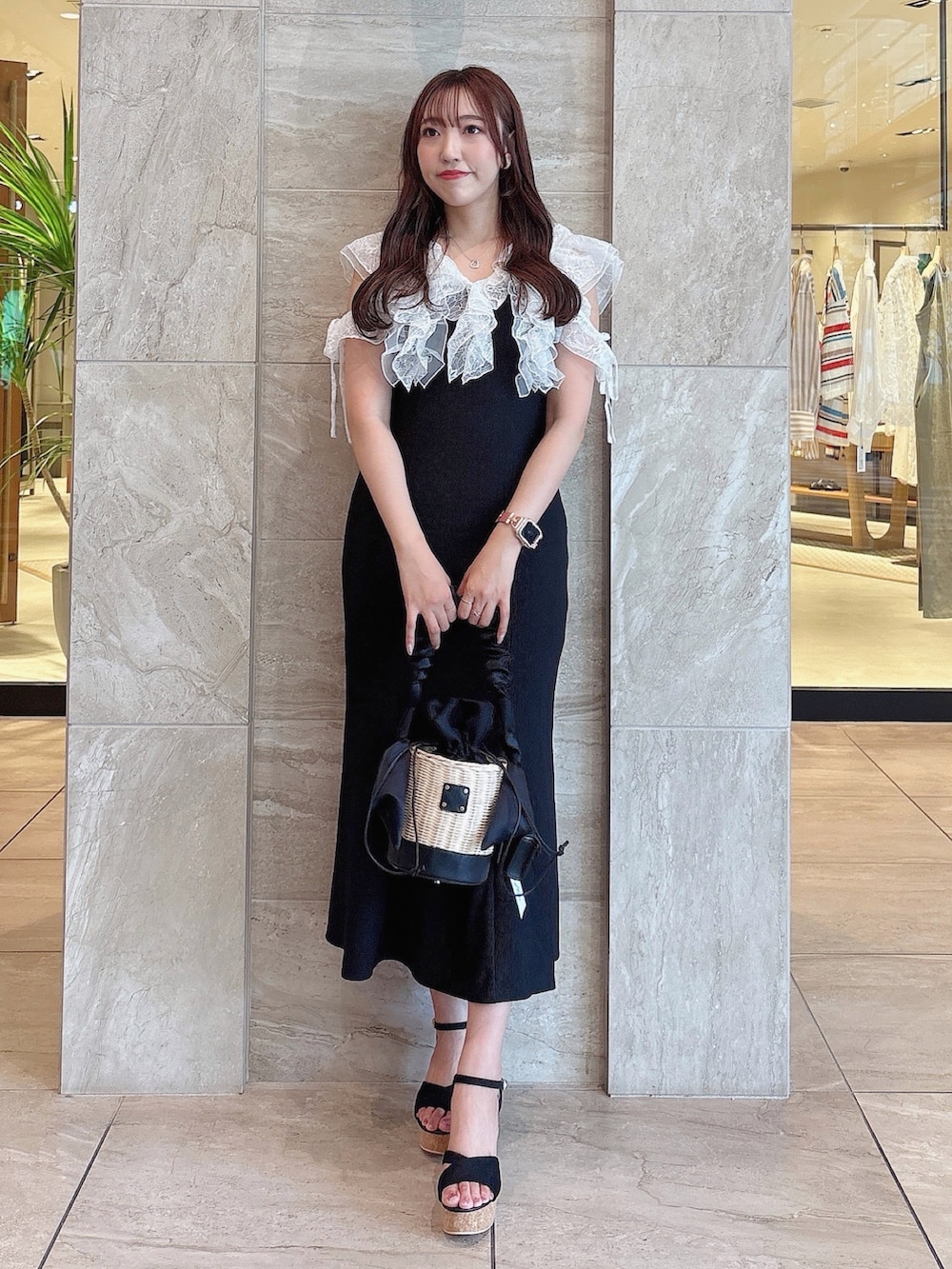 ブラック系のワンピース、ブラック系のサンダル、ブラック系のかごバッグを着用したレディースの夏コーディネートの5枚目の写真