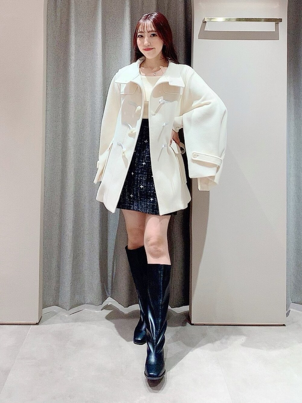 ホワイト系のダッフルコート、ホワイト系のニット/セーター、ブラック系のスカートを着用したレディースの秋コーディネートの6枚目の写真