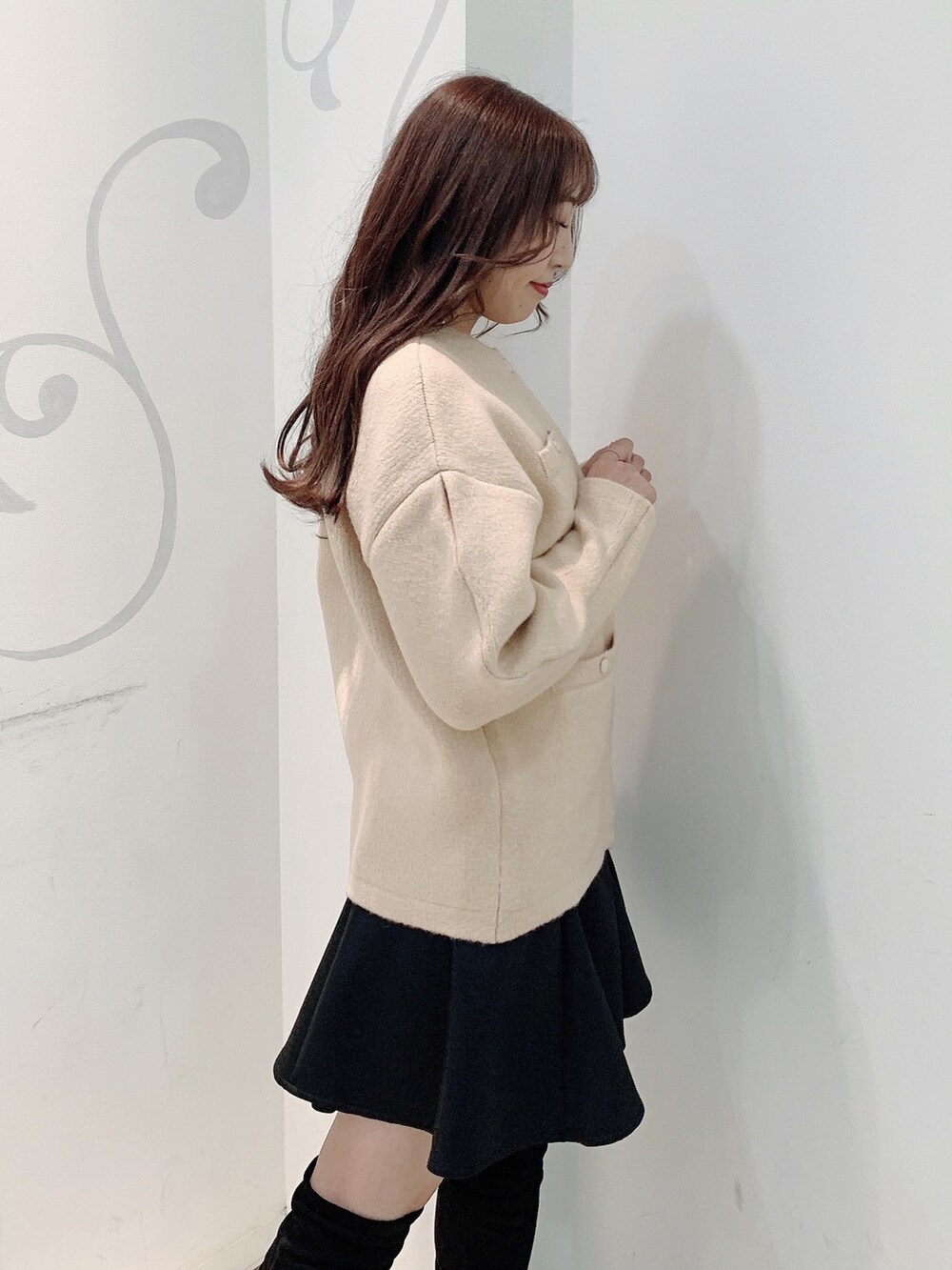 ベージュ系のカーディガン/ボレロ、ブラック系のスカートを着用したレディースの秋コーディネートの6枚目の写真