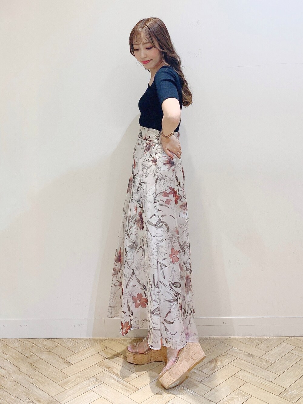 ピンク系のスカート、ブラック系のニット/セーター、その他のサンダルを着用したレディースの春コーディネートの4枚目の写真