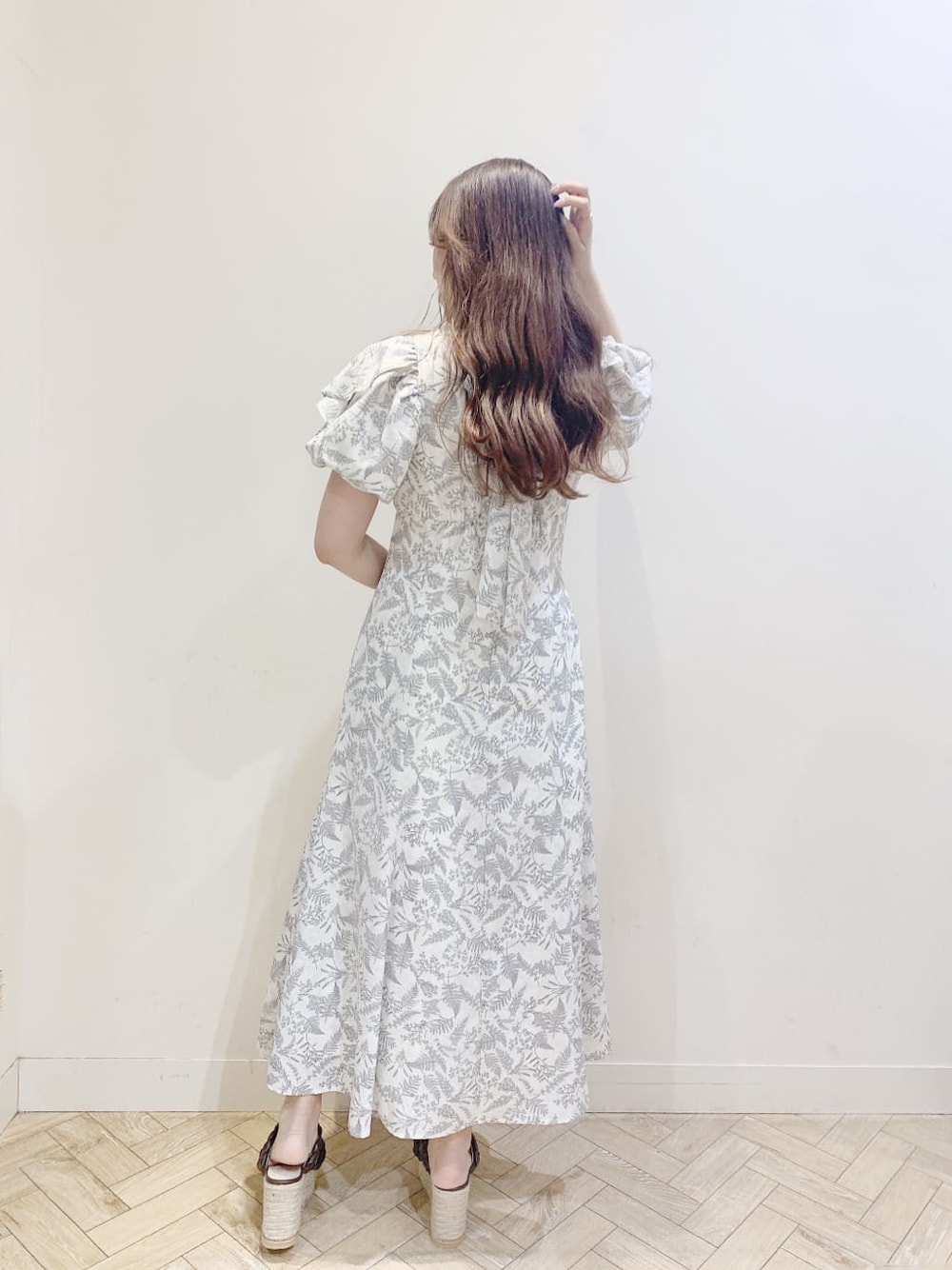 ホワイト系のワンピース、ブラウン系のサンダルを着用したレディースの春コーディネートの3枚目の写真