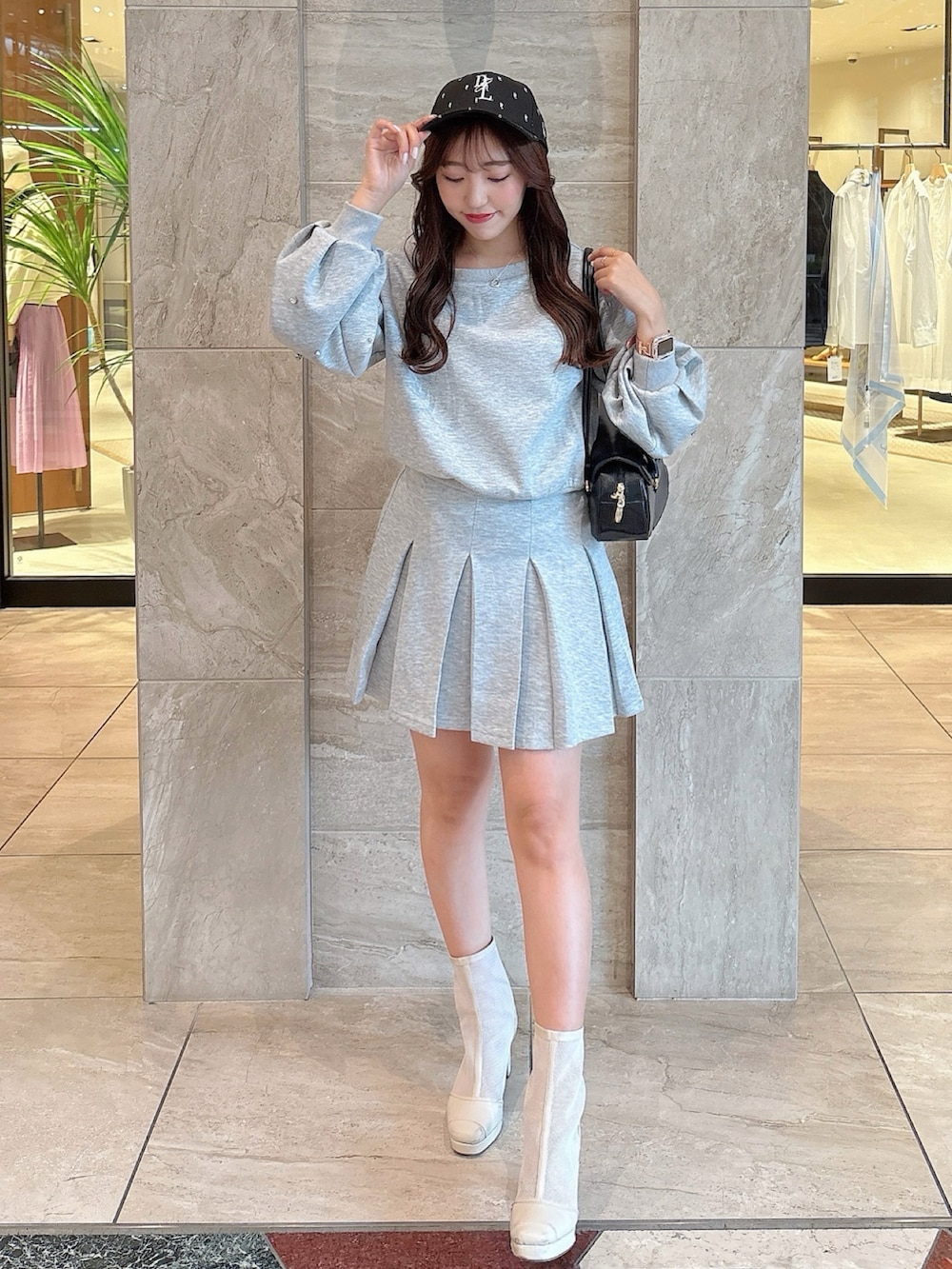 ホワイト系のブーツ、グレー系のスカート、グレー系のスウェットを着用したレディースの春コーディネートの2枚目の写真