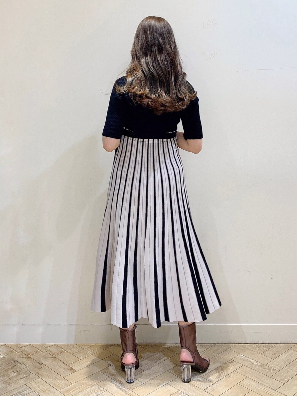 ブラック系のワンピース、ブラウン系のブーツを着用したレディースの春コーディネートの7枚目の写真