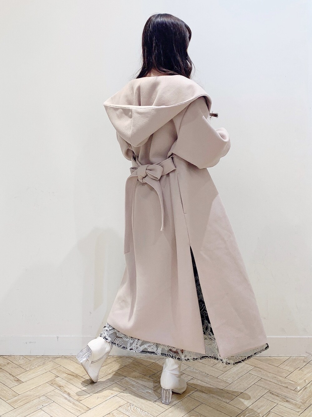 ブラック系のスカート、ホワイト系のニット/セーター、ベージュ系のチェスターコートを着用したレディースの冬コーディネートの4枚目の写真