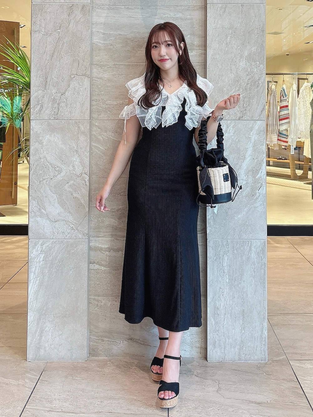 ブラック系のワンピース、ブラック系のサンダル、ブラック系のかごバッグを着用したレディースの夏コーディネートの2枚目の写真