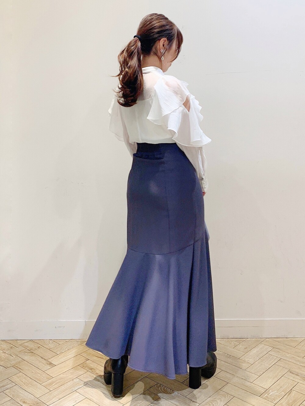 ホワイト系のシャツ/ブラウス、グレー系のスカート、ブルー系のハンドバッグを着用したレディースの冬コーディネートの5枚目の写真