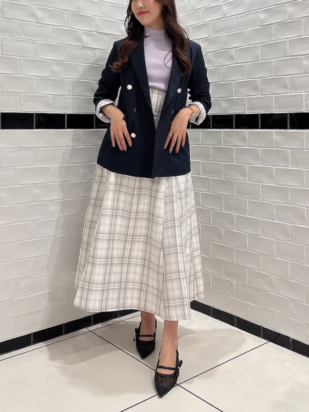 イエロー系のスカート、パープル系のニット/セーター、ブラック系のパンプスを着用したレディースの春コーディネートの5枚目の写真