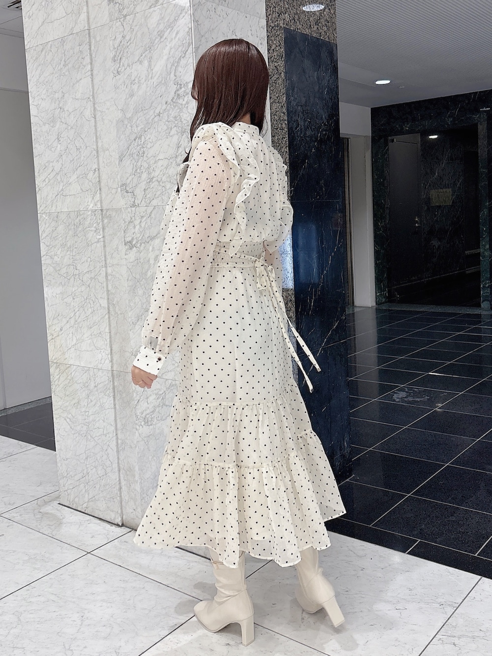 ホワイト系のワンピース、ホワイト系のブーツを着用したレディースの冬コーディネートの3枚目の写真