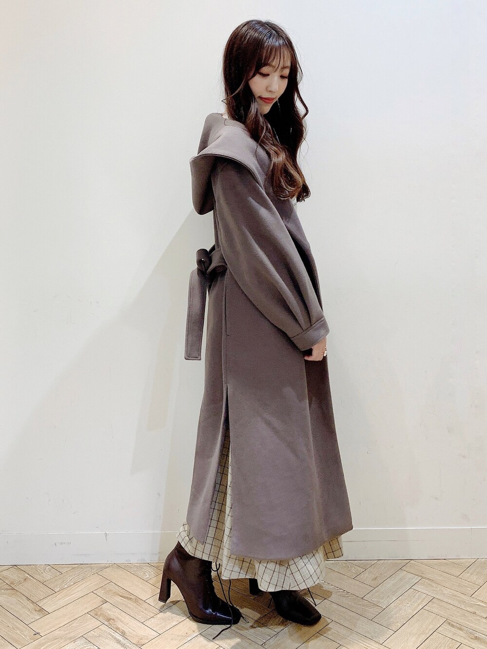 ブラウン系のチェスターコート、ブラウン系のブーツ、ベージュ系のワンピースを着用したレディースの冬コーディネートの9枚目の写真