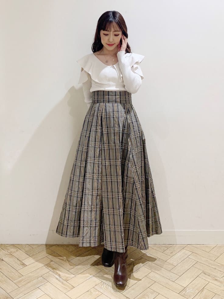 ベージュ系のスカート、ホワイト系のニット/セーター、ベージュ系のスカートを着用したレディースの秋コーディネートの3枚目の写真