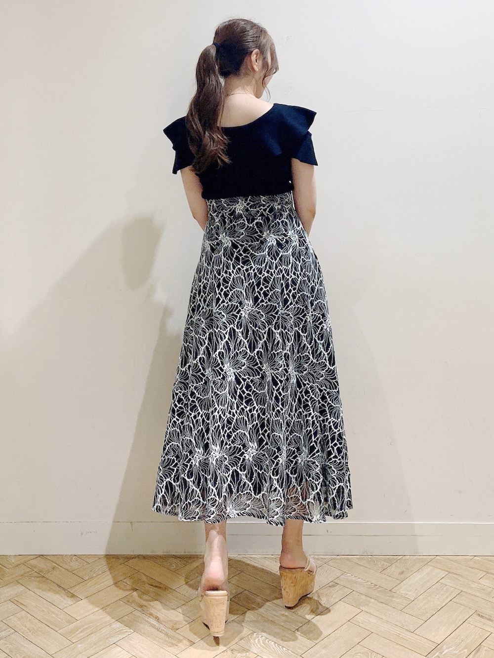 ブラック系のニット/セーター、ブラック系のスカートを着用したレディースの夏コーディネートの7枚目の写真