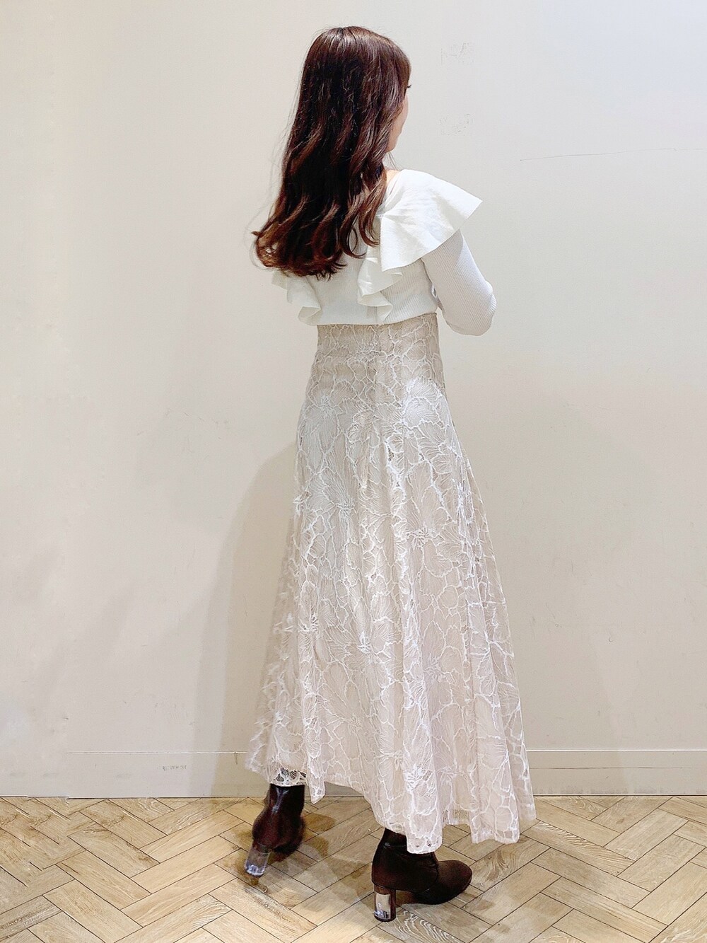 ベージュ系のスカート、ブラウン系のブーツ、ホワイト系のニット/セーターを着用したレディースの冬コーディネートの7枚目の写真