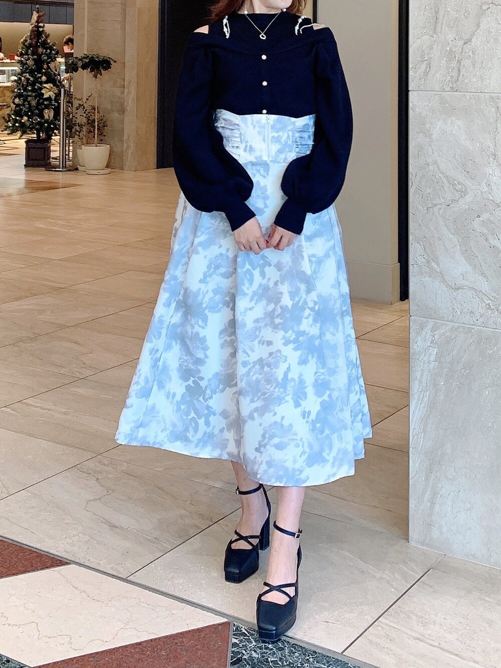 ホワイト系のスカート、ブラック系のニット/セーター、ブラック系のパンプスを着用したレディースの秋コーディネートの3枚目の写真