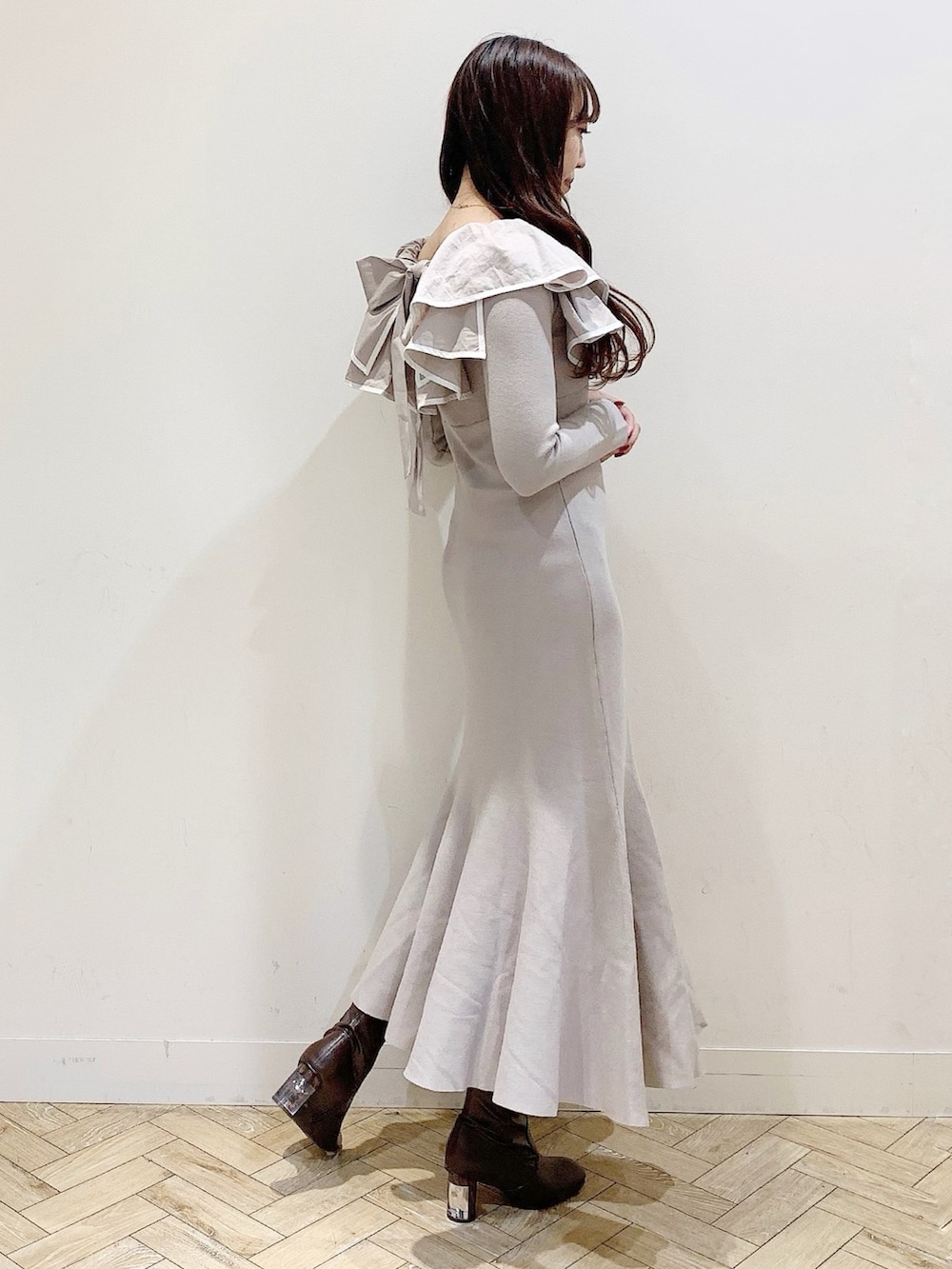 ベージュ系のワンピース、ホワイト系のチェスターコート、ブラウン系のブーツを着用したレディースの冬コーディネートの5枚目の写真