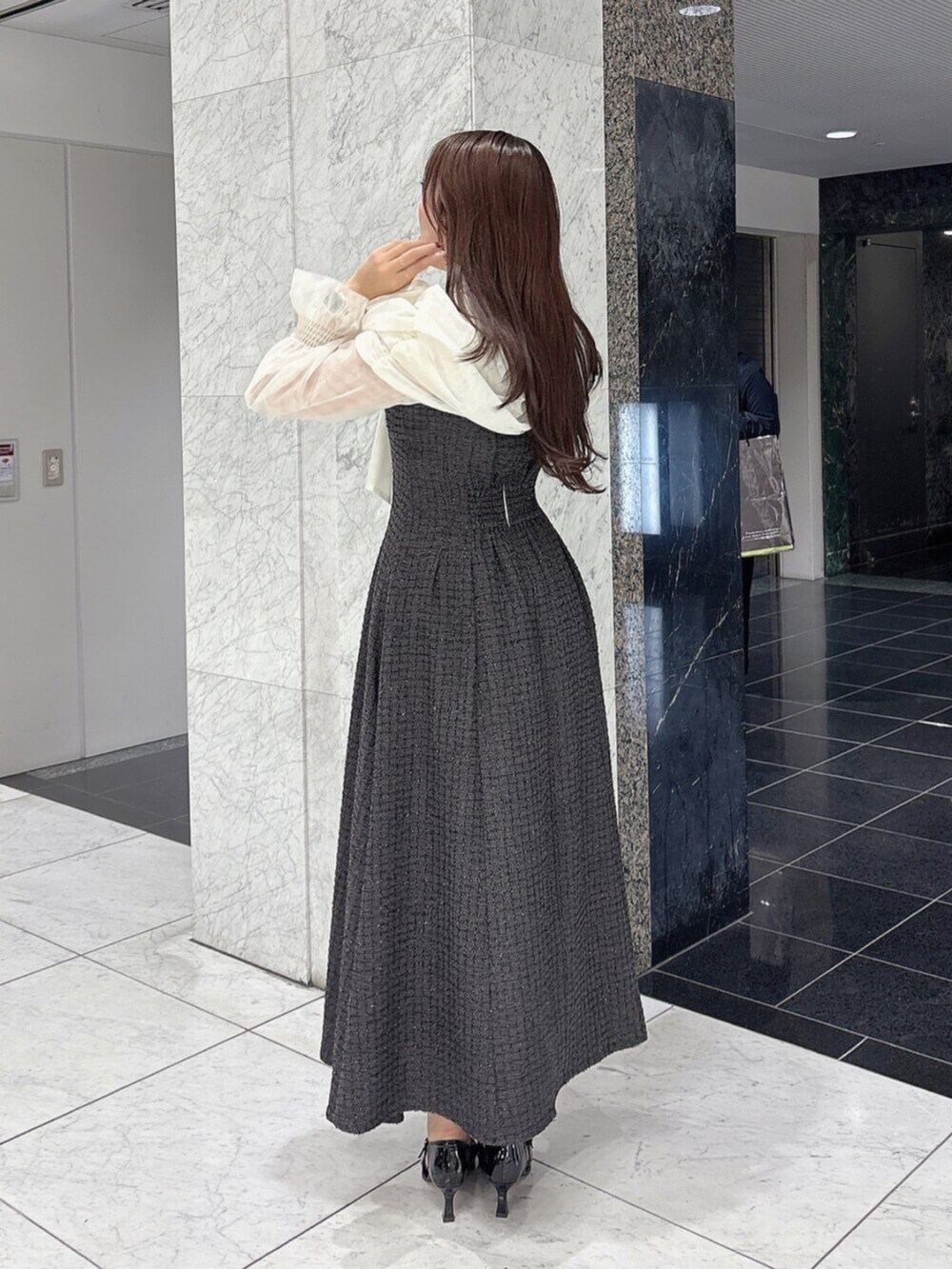 ブラック系のパンプス、ブラック系のドレスを着用したレディースの冬コーディネートの3枚目の写真