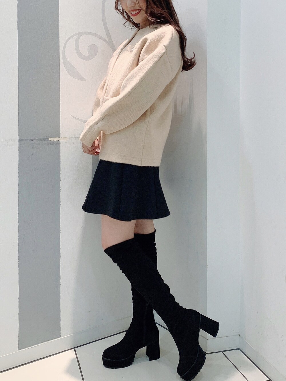 ベージュ系のカーディガン/ボレロ、ブラック系のスカートを着用したレディースの秋コーディネートの2枚目の写真