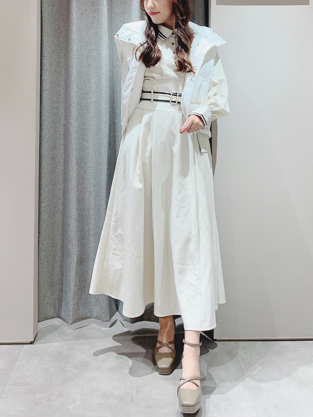 ベージュ系のパンプス、ホワイト系のワンピース、ホワイト系のダウンジャケット/コートを着用したレディースの秋コーディネートの7枚目の写真